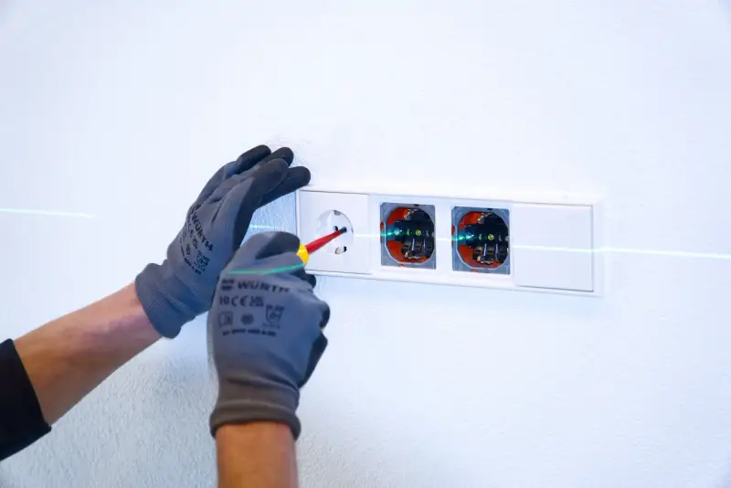 Montage von Unterputzsteckdosen mit Laserlinie an der Wand